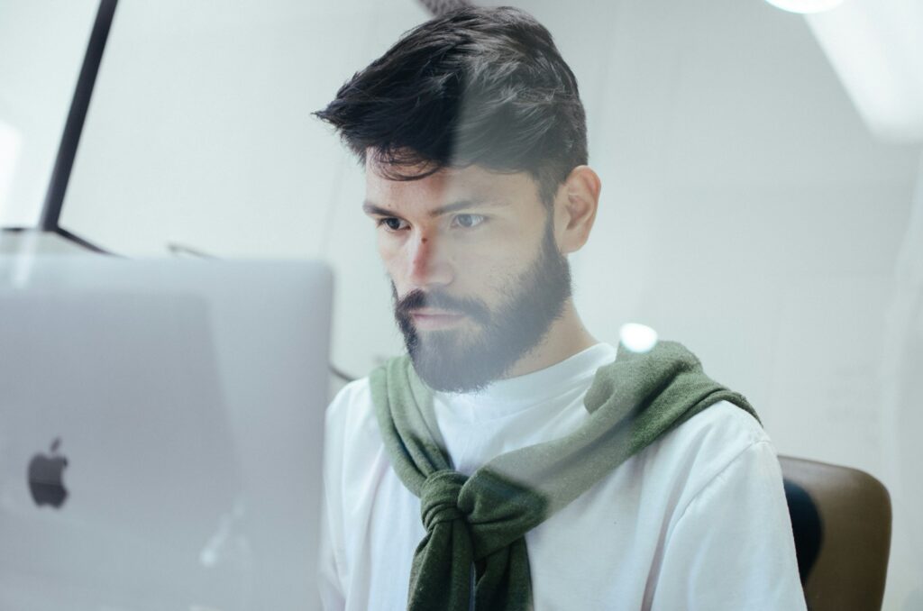 Photo by Miguelangel Miquelena man facing MacBook Pro